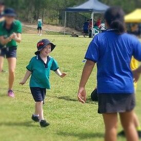Child being cheered while walking a sports field